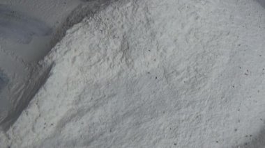 Çiftçinin eli un temizlemek için sepeti kullanıyor.