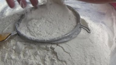 Çiftçinin eli un temizlemek için sepeti kullanıyor.