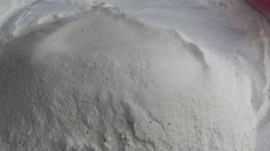 Çiftçinin eli un temizlemek için sepeti kullanıyor.