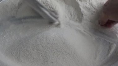 Çiftçinin eli un temizlemek için sepeti kullanıyor.