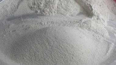 Çiftçinin eli un temizlemek için sepeti kullanıyor.