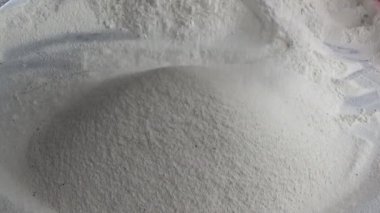 Çiftçinin eli un temizlemek için sepeti kullanıyor.