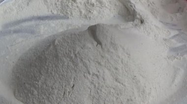 Çiftçinin eli un temizlemek için sepeti kullanıyor.