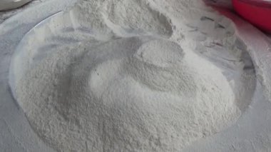 Çiftçinin eli un temizlemek için sepeti kullanıyor.