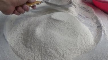 Çiftçinin eli un temizlemek için sepeti kullanıyor.