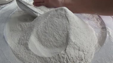 Çiftçinin eli un temizlemek için sepeti kullanıyor.