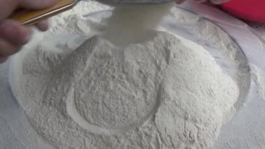 Çiftçinin eli un temizlemek için sepeti kullanıyor.