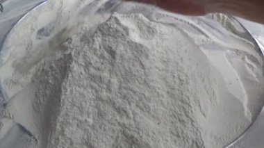 Çiftçinin eli un temizlemek için sepeti kullanıyor.