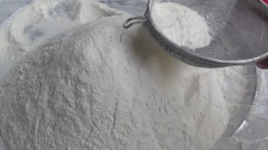 Çiftçinin eli un temizlemek için sepeti kullanıyor.