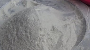 Çiftçinin eli un temizlemek için sepeti kullanıyor.