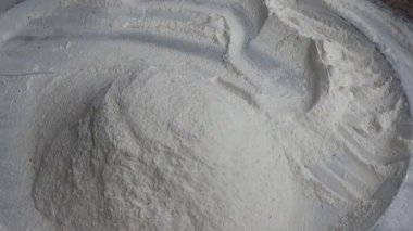 Çiftçinin eli un temizlemek için sepeti kullanıyor.