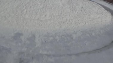 Çiftçinin eli un temizlemek için sepeti kullanıyor.