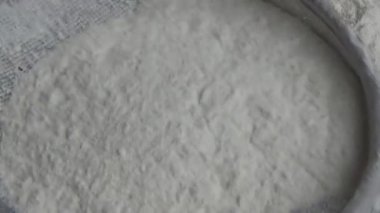 Çiftçinin eli un temizlemek için sepeti kullanıyor.