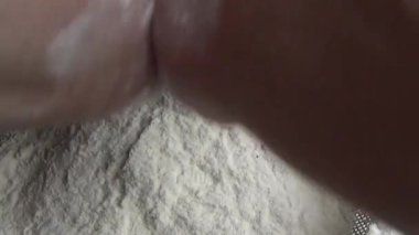 Çiftçinin eli un temizlemek için sepeti kullanıyor.