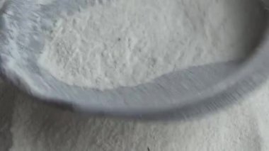 Çiftçinin eli un temizlemek için sepeti kullanıyor.