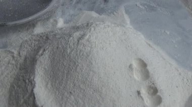 Çiftçinin eli un temizlemek için sepeti kullanıyor.