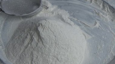 Çiftçinin eli un temizlemek için sepeti kullanıyor.