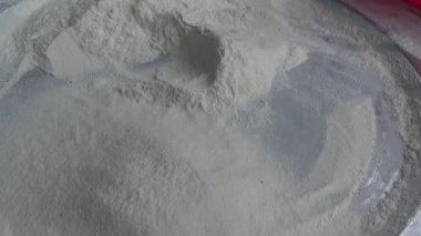 Çiftçinin eli un temizlemek için sepeti kullanıyor.