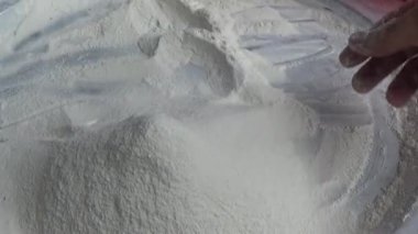 Çiftçinin eli un temizlemek için sepeti kullanıyor.