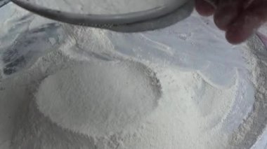 Çiftçinin eli un temizlemek için sepeti kullanıyor.