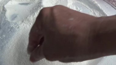 Çiftçinin eli un temizlemek için sepeti kullanıyor.