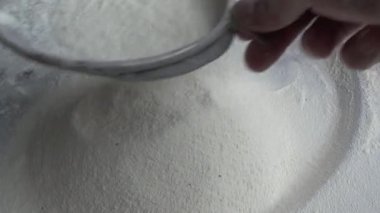 Çiftçinin eli un temizlemek için sepeti kullanıyor.