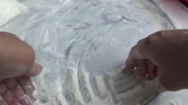 Çiftçinin eli un temizlemek için sepeti kullanıyor.