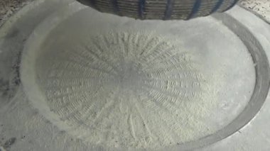 Çiftçinin eli un temizlemek için sepeti kullanıyor.