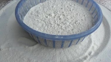 Çiftçinin eli un temizlemek için sepeti kullanıyor.