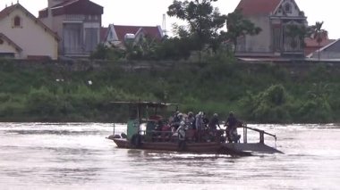 22 Ağustos 2025. Chu Van An, Hai Phong, Vietnam. Vietnam 'daki Kinh Thay Nehri' nde bir feribot gezisi. Feribot sel mevsiminde nehrin karşısına geçer. Bu feribotta bir sürü insan, motosiklet, bisiklet ve elektrikli bisiklet var.