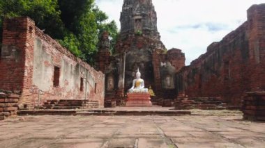 AYUTTHAYA, THAILAND - 14 Temmuz 2024: Antik Buda heykeli Wat Choeng Tha tapınağının tarihi kalıntıları ile birlikte 14 Temmuz 2024 'te Tayland' ın Ayutthaya kentinde