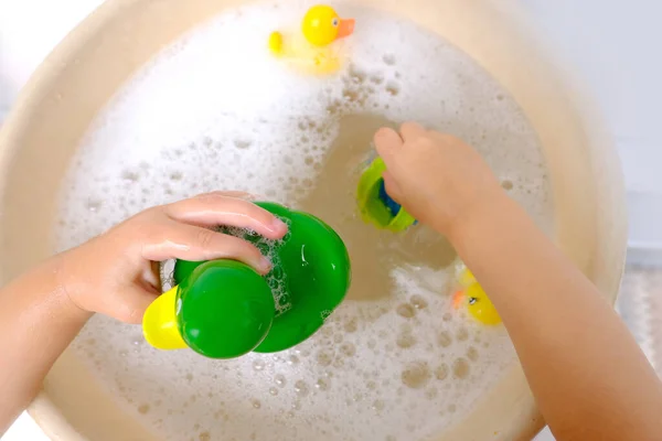 幸せな子供 女の子3歳はゴムグリーンで遊ぶ 水泳のための黄色のアヒル 石鹸泡で子供のおもちゃ 浴槽で入浴の概念 水で遊ぶ 赤ちゃんの衛生 健康的なライフスタイル — ストック写真