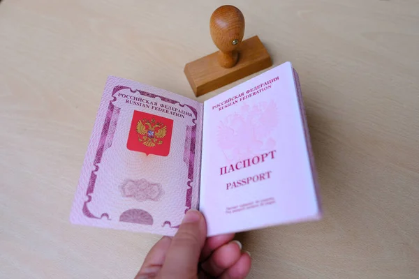 手の中にロシアのパスポート赤いカバー スタンプでロシア連邦市民の国際バイオメトリックパスポート 不法移民の概念を停止します ビザの禁止と停止 — ストック写真