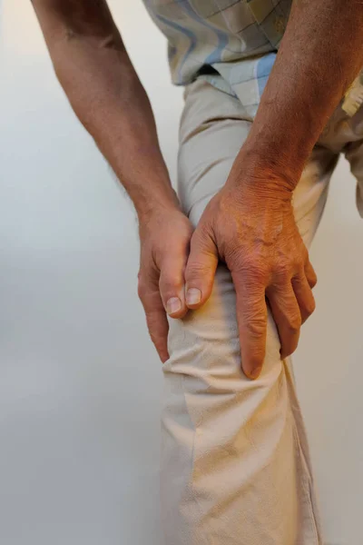 stock image closeup male hand on knee, mature man with joint pain, senior 60 years old is sick, concept health, diagnosis, treatment diseases ligament injury, torn meniscus, fracture, Knee bursitis