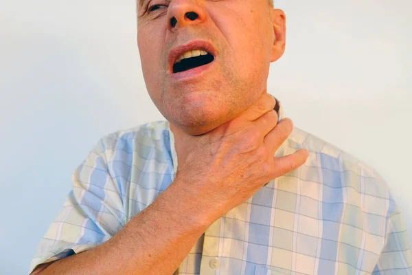 首に男性の手のクローズアップ 成熟したカリスマ男は喉を保持します シニア60歳は病気です 健康の概念 診断治療甲状腺の概要 甲状腺炎症 声の損失 — ストック写真