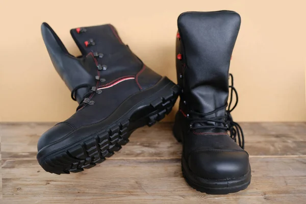 新しい黒の安全靴のペアのクローズアップ 古い木の板に強化ケープと革で作られた作業ブーツ 特別な保護作業服の概念 プロの靴 作業安全 — ストック写真