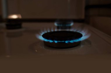 gas stove with fire, close-up side view of flame, natural gas at home for cooking food, concept of environmental problems of gas industry, global gas market, growth of tariffs for utility costs