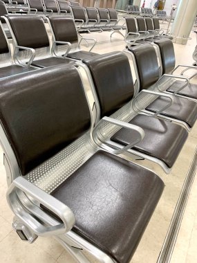 comfortable metal rows of seats in bright airport lounge, Airport waiting room, concept passenger traffic, delay, flight cancellation, arrival time, international voyage, modern furniture