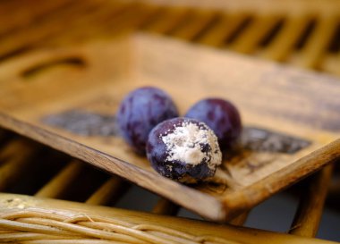 close-up of blueberry, black berries covered with gray, white fluffy mold, concept mold fungi on surface products, spore contamination food, mycotoxins affect people's health, rotting food