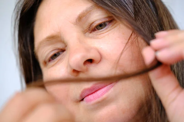 Mature Woman Carefully Examines Strand Her Long Hair Concept Hair — Stockfoto