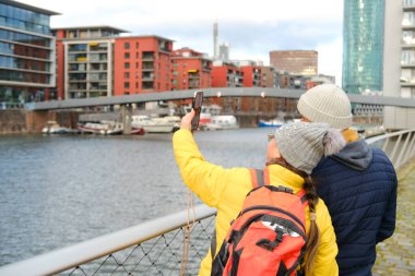 mature woman 50 years and mature man 60 years, elderly couple, adult husband and wife looking display of modern mobile phone, viewing content together, reads news, communicates on Internet, technology