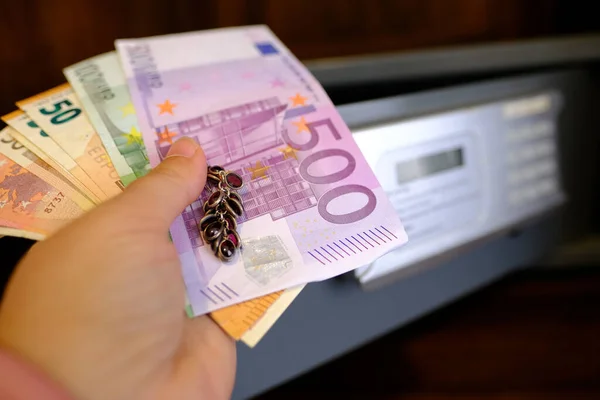 stock image closeup female hands holds 50, 500 euro banknotes of european union, jewelry, tourist puts money in hotel mini safe with electronic lock, concept protect from during travel, vacation, secure storage