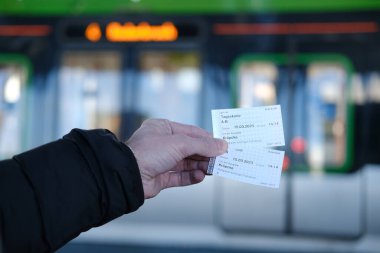 Yolcu, erkek el biletleri, toplu taşıma biletleri, Hannover Stadtbahn treni, tipik Alman toplu taşımacılığı Stadtbahn seyahat platformu, Hannover, Almanya - Mart 2023