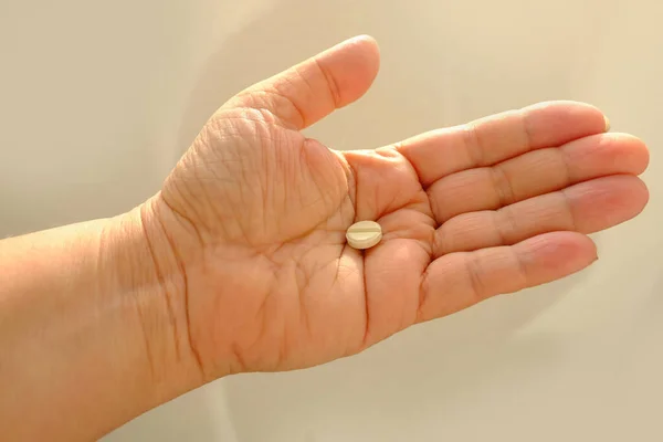 白い殻の薬白い背景の女性の手の上に薬を閉じます 鎮痛剤を取る概念 健康を維持します 薬物治療 ビタミン 意図的な薬物過剰摂取 — ストック写真