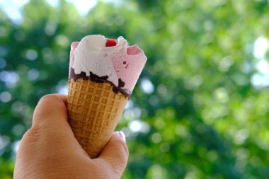 Kadın eli yakın çekim, dondurma yemeye gitmek, meyve reçeli ve çikolatalı çilekli tatlı, iştah açıcı yemek, mutlu çocukluk konsepti, çocukların lezzeti, sağlıklı ve sağlıksız yiyecekler.