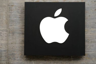 Girişin üstündeki modern bina cephesi üzerine Apple Inc. logosu, siyah zemin üzerinde ısırılmış beyaz elma, nalbur mağazasının sembolü, Hannover, Almanya - Mart 2023