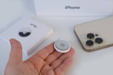 Yeni elektronik takip cihazı Apple Airtag kadın elinde, iPhone 14, takip cihazı güvenli sinyal Bluetooth yayınlıyor, yakınlardaki cihazları alıyor, coğrafi konumlama, çocuk güvenliği kavramı, araba hırsızlığı önleyici cihaz