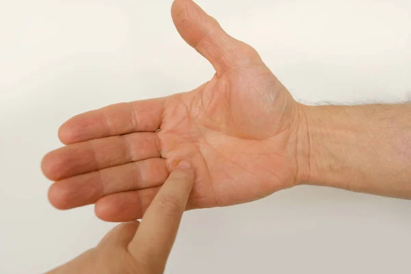 closeup of male hand of adult mature man in gesture fingers holding, palm reading, shows, open palm on white background, concept of Palmistry, fortune teller reading line on male palm of hand