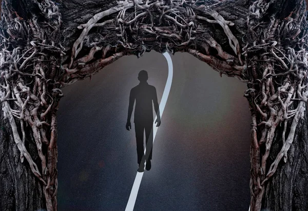 黒いシルエットの男と暗い道の光線怖いシュールな枝のフレームトンネルの端の光の概念生きているエネルギー死別の世界への移行悪い状況はすぐに終わる — ストック写真