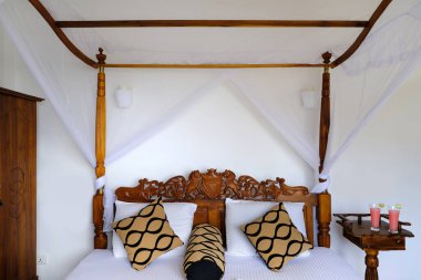 Sivrisinek ağlı rahat yatak odası, beyaz örtü örtüsü, apartman odasındaki ahşap yatak odası, dört direkli yatağın yanındaki otel, sivrisinek ağlı rahat yatak odası, tropikal bölgede tatilin tadını çıkarıyor.